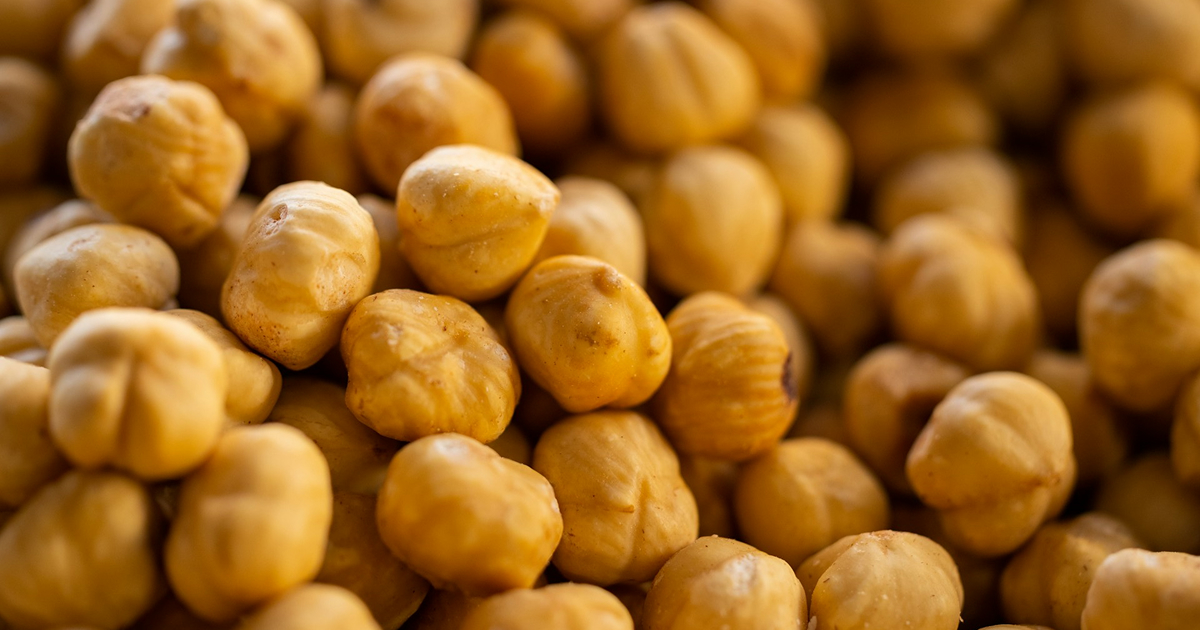 Close-up of shelled hazelnuts piled together, filling the frame.