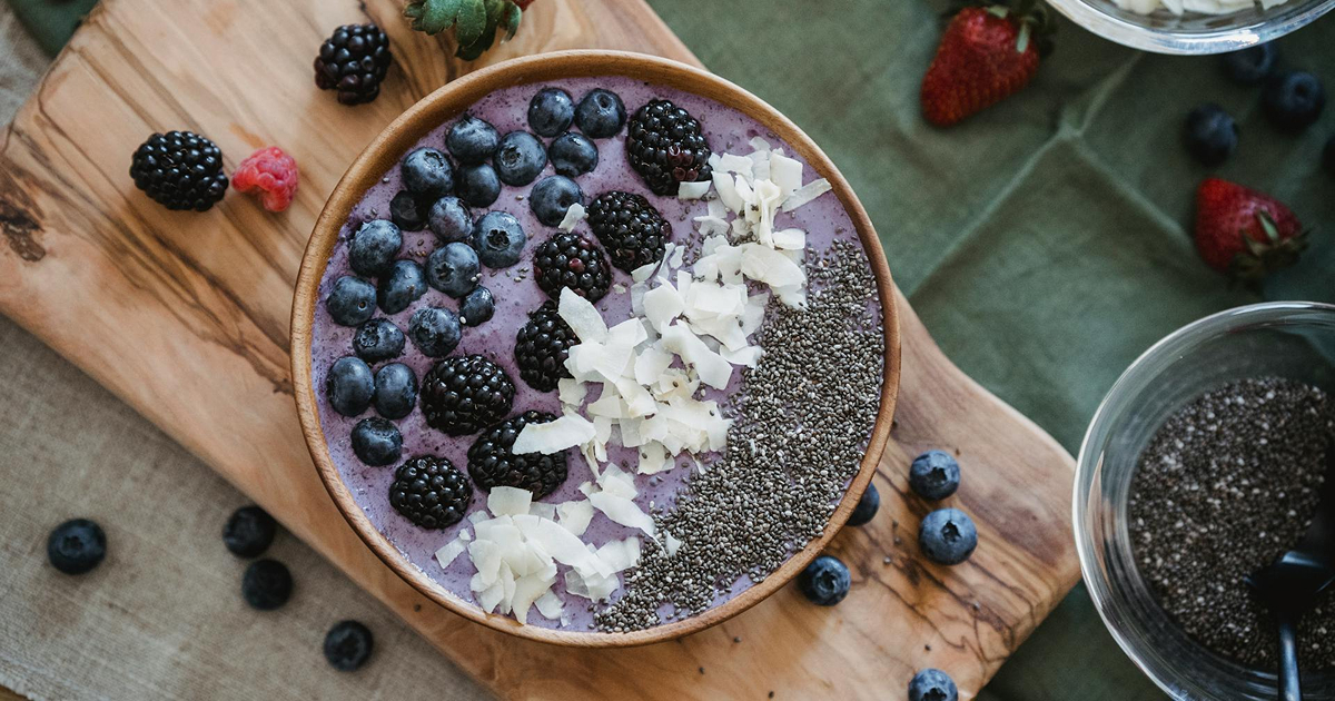 Purple berry smoothie bowl with blueberries, blackberries, chia and coconut flakes