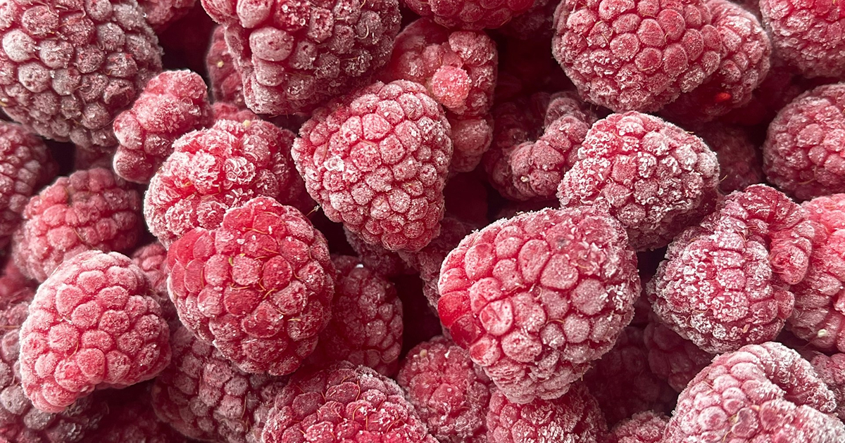 Frozen raspberries close-up, coated in frost crystals.