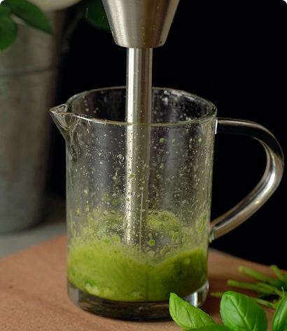 Leafy greens and a green smoothie in a blender